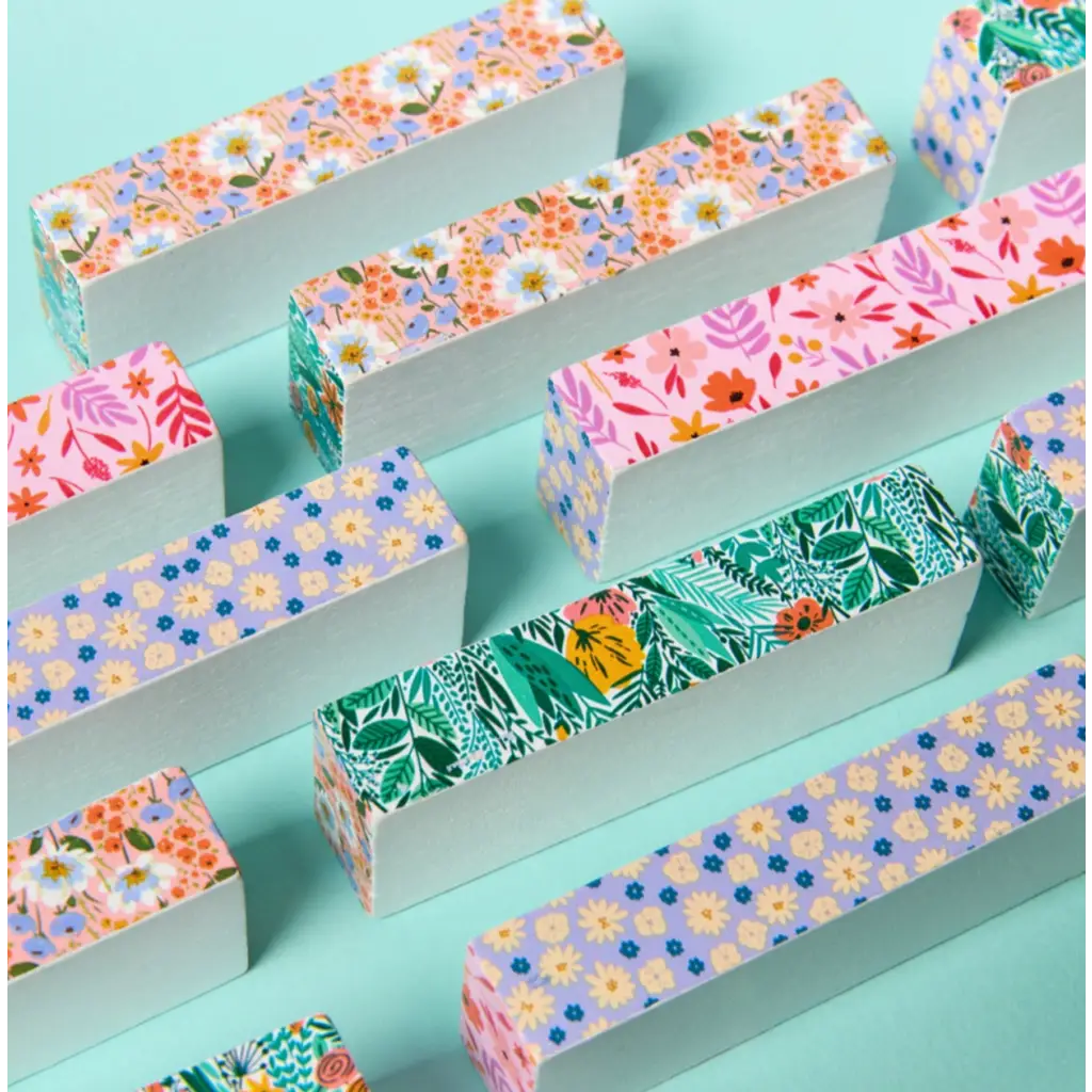 Colorful patterned paper-wrapped bars for the Floral Tumbling Tower Game in pink box