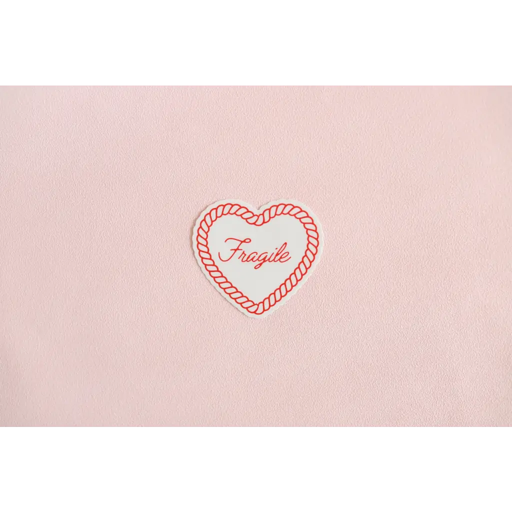 Red embroidered heart fragile sticker on pink fabric for soft girl inspired vibes