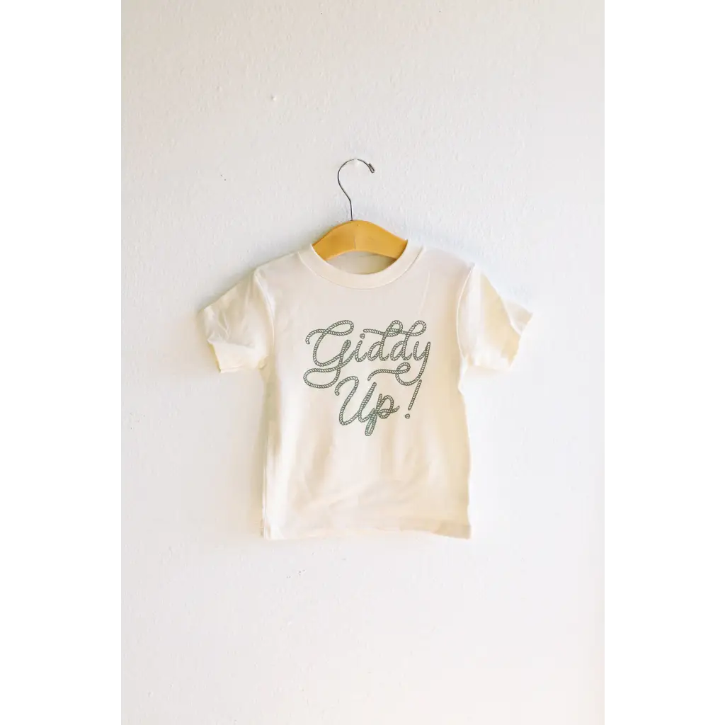 White softest cotton graphic t-shirt with Giddy Up text hanging on a hanger