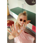 Playful kid in pink sunglasses and shirt showcasing the Gingham All Day Twirl Dress