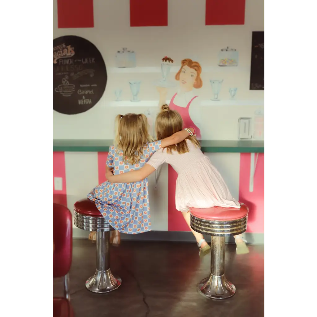 Two kids enjoying a retro diner in a cute Gingham All Day Twirl Dress