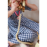 Vintage cream phone with brass accents beside gingham bamboo twirl dress