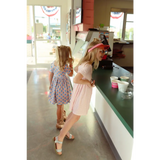 Two people in summer dresses at a counter showcasing trendy Gingham All Day styles