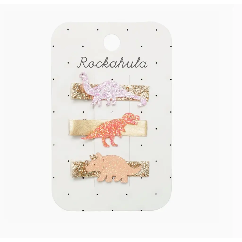 Three bright glittery dinosaur bar clips in pink, coral, and peach on Rockahula card