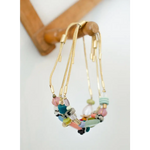 Colorful gold pull tie beaded bracelet with pastel hues and metal accents