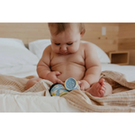 Baby checks Good Baby organic honey jars on bed for chapped cheeks balm