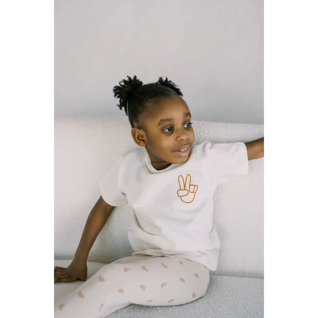 Child in a Rad Pre Washed T-shirt with peace sign, ready for the toughest play