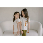 Two kids in white pre washed tees with animal designs, ready for the toughest play