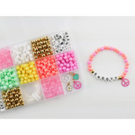 Pink beaded bracelet with letters and peace charm from Groovy Goals DIY Bracelet Craft Kit