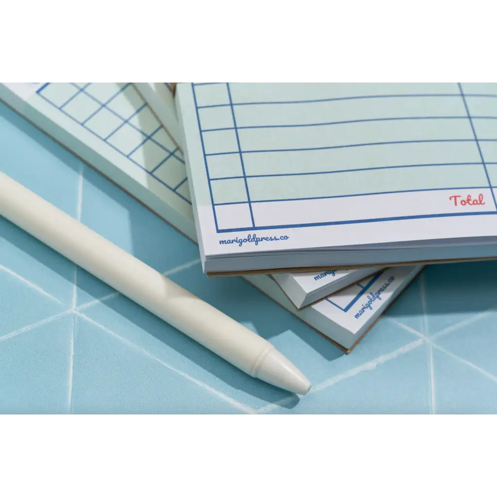 Stack of notepads with a pen for Grocery List, perfect for stylish moms or polished prints