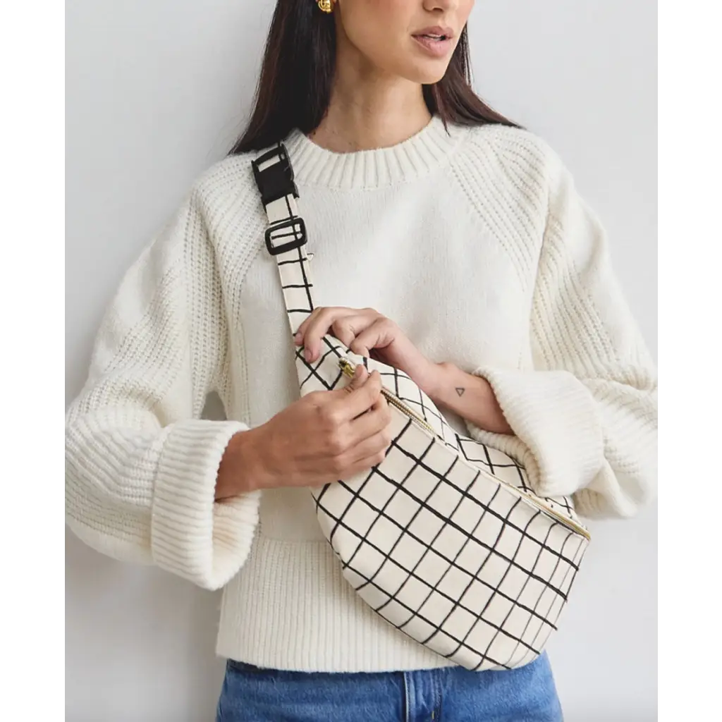 White grid-patterned sling bag with interior slip pocket for style and convenience
