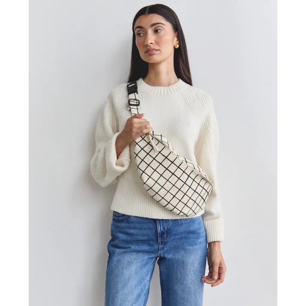 Woman in white sweater and blue jeans with a Handmade Block Print Grid Sling Bag featuring an interior slip pocket