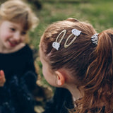Happy Ghost Clips with stylish womens clothes holding back a young girl’s brown hair
