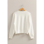 White Hazel Relaxed Long Sleeve Sweatshirt on a wooden hanger, perfect stylish womens clothes