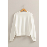 White Hazel Relaxed Long Sleeve Sweatshirt on a wooden hanger, perfect stylish womens clothes