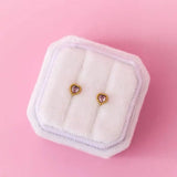 Gold heart gemstone stud earrings with pink stones in fur box