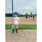 Young kid in a baseball cap and brutally honest tee made from organic cotton