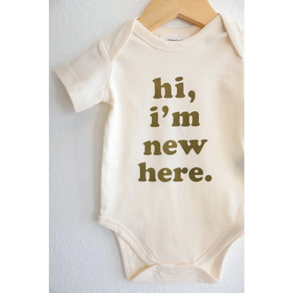 Adorable white baby onesie with olive green text saying hi, I’m new here, fits closer for 3mo