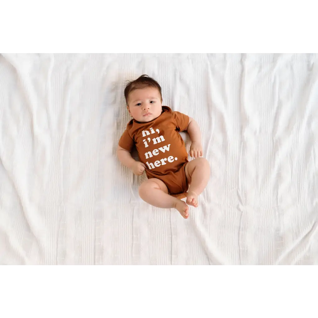 Cute baby in a brown onesie saying I’m new here, perfect for 3mo fits closer