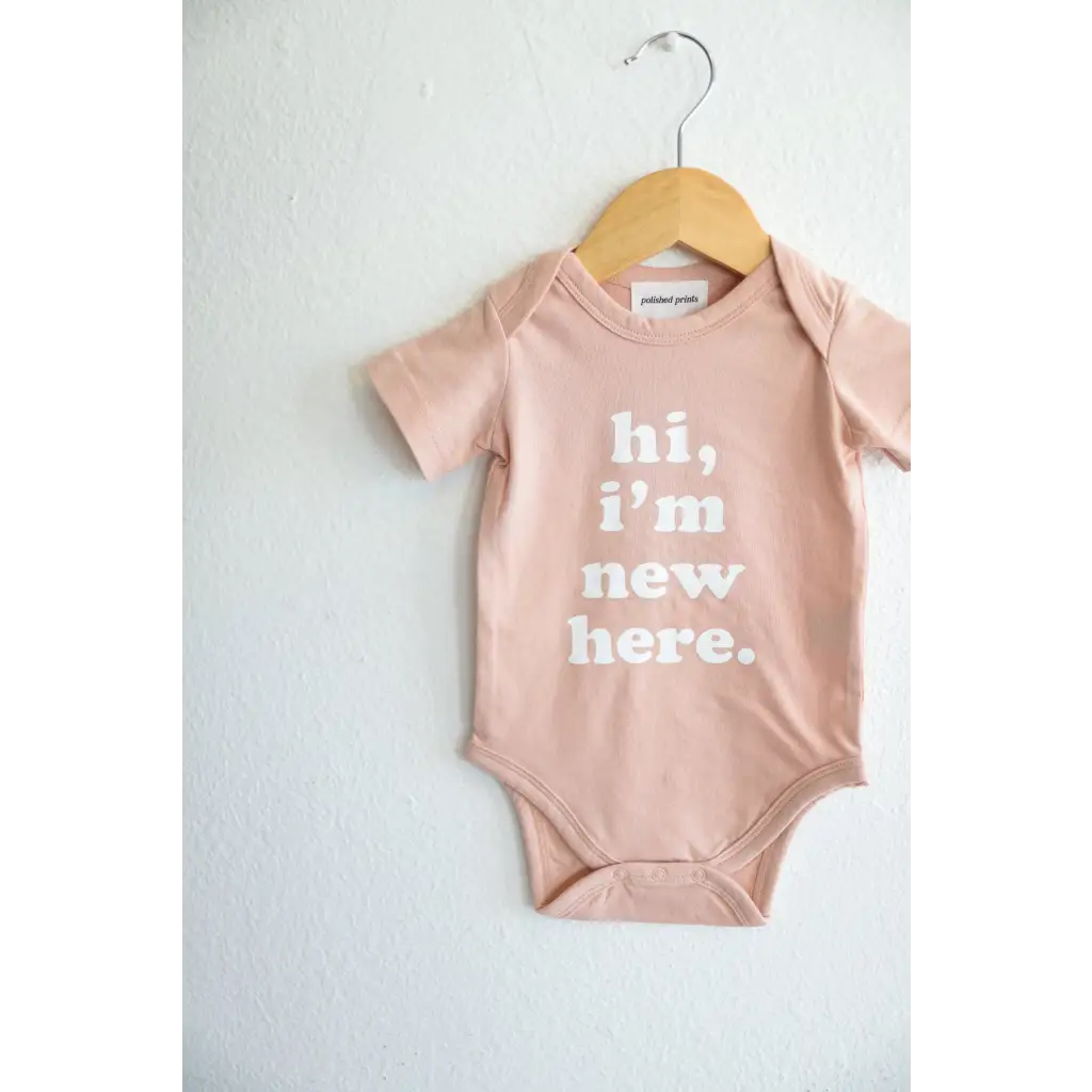 Pink baby onesie on a hanger from Hi, I’m New Here in soft organic cotton