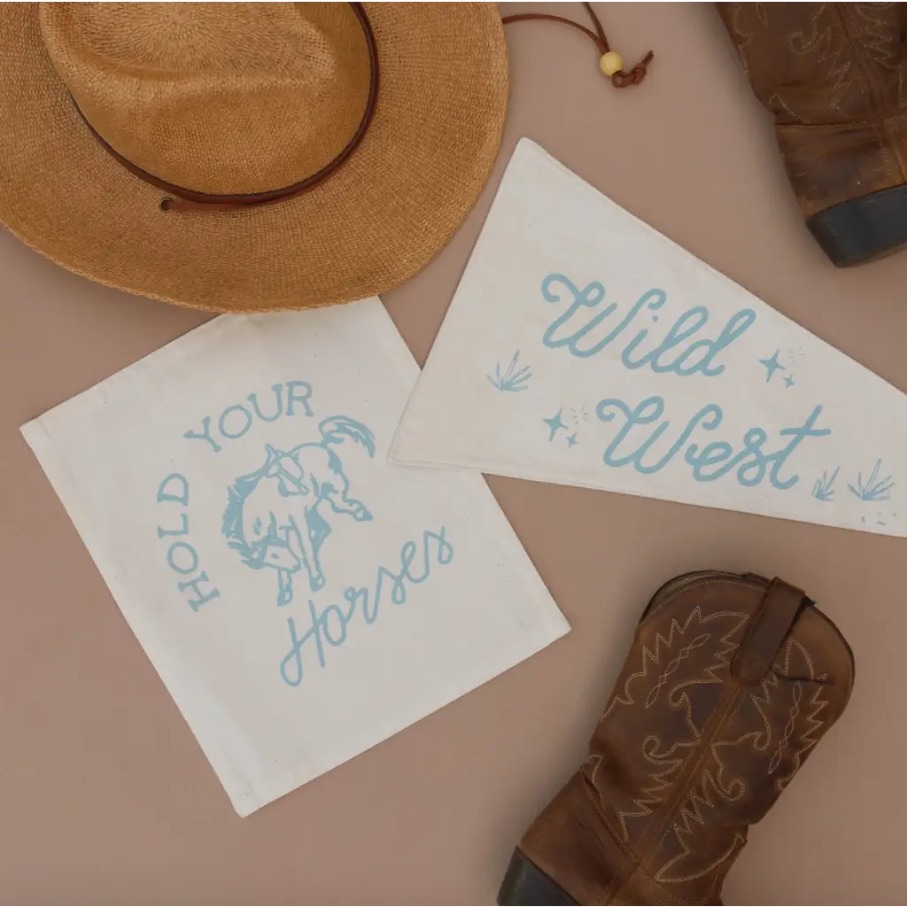Two white canvas banners featuring blue western text and bucking bronco design