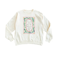 Cream-colored long-sleeved sweatshirt with good day script in polished prints