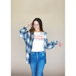 Person in plaid shirt over It Takes a Village Adult Retro Ringer Tee and blue jeans