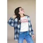 Blue plaid flannel over a white graphic tee and jeans for the It Takes a Village Adult Retro Ringer