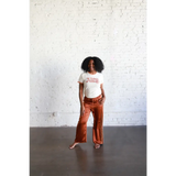 Person wearing a white Adult Retro Ringer Tee with rust-colored wide-leg pants