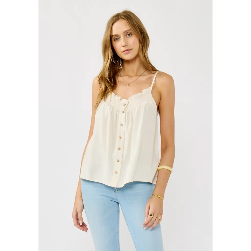 Woman wearing a stylish womens clothes cream-colored spaghetti strap button-down top