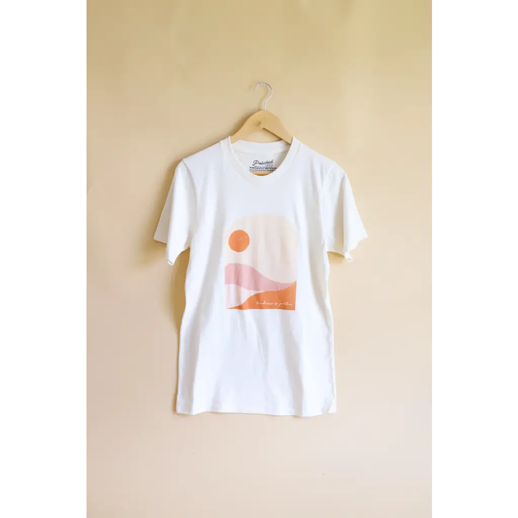 Golden Relaxed Graphic Tee featuring a minimalist orange sun and landscape design