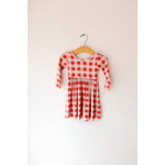 Cute red and white gingham Kit Plaid Dress hanging on a wooden hanger, perfect for twirling