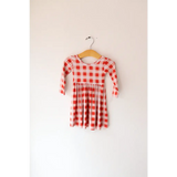 Cute red and white gingham Kit Plaid Dress hanging on a wooden hanger, perfect for twirling