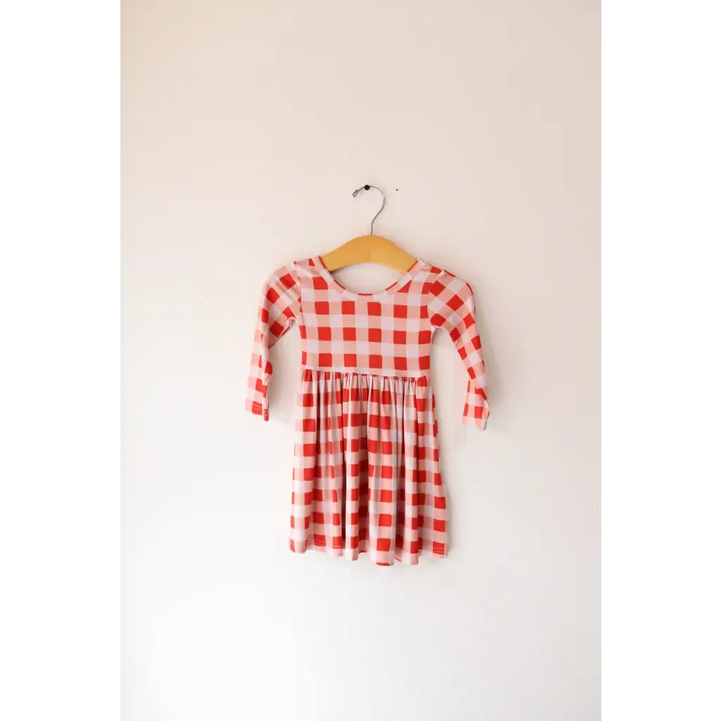 Red and white gingham Kit Plaid Dress for Girls hanging on a hanger ready to twirl