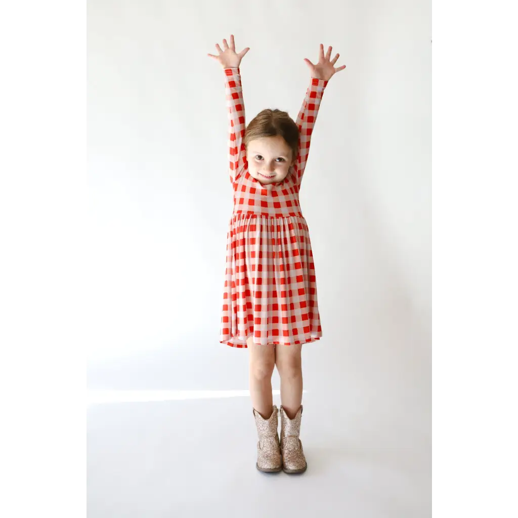 Red and white checkered Kit Plaid Dress for girls with stylish boots, perfect for twirling