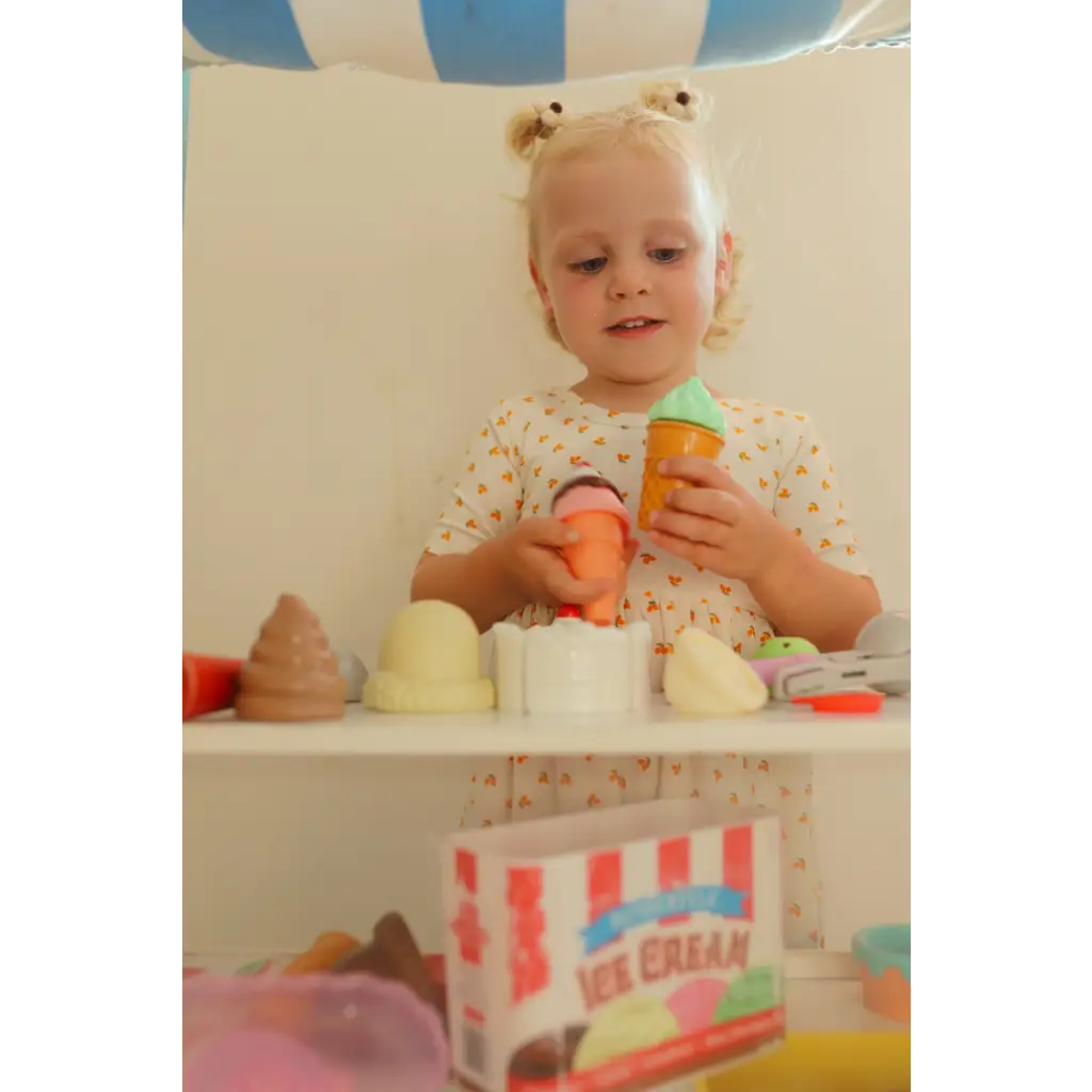 Child in Lemon Shake Up Day Twirl Dress having fun with toy ice cream cones