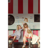 Three kids enjoying fun at a diner in a Lemon Shake Up Twirl Dress with floral print