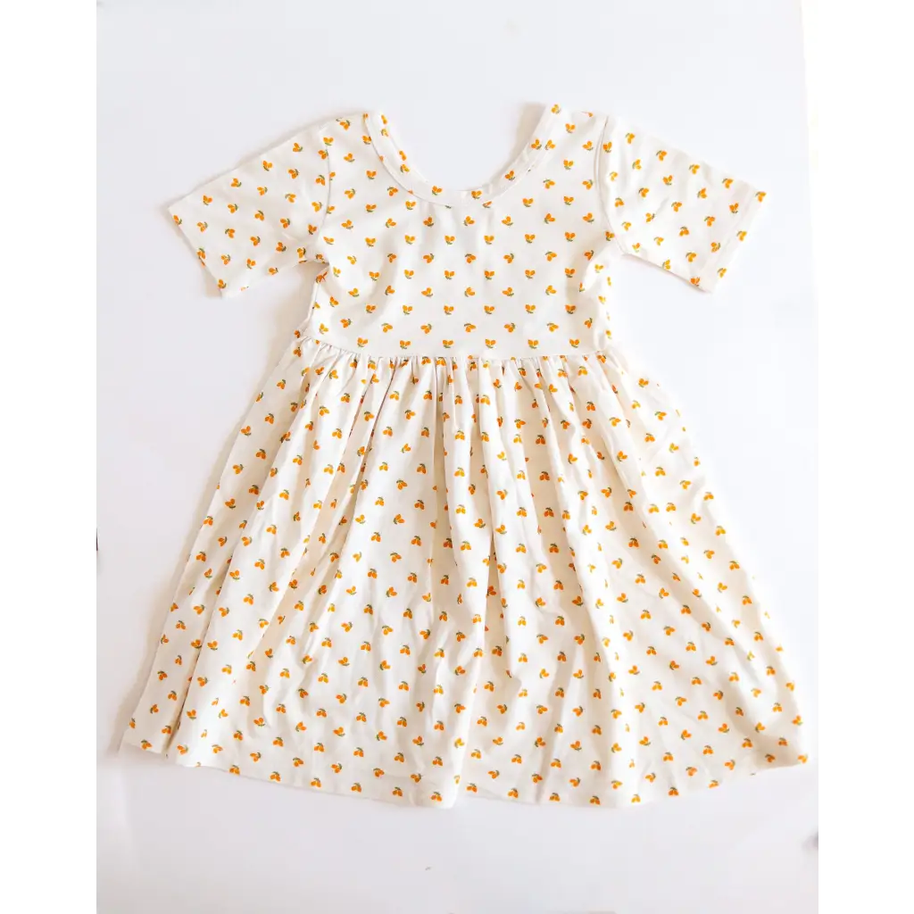 Lemon Shake Up Twirl Dress features a white fabric with tiny orange floral print