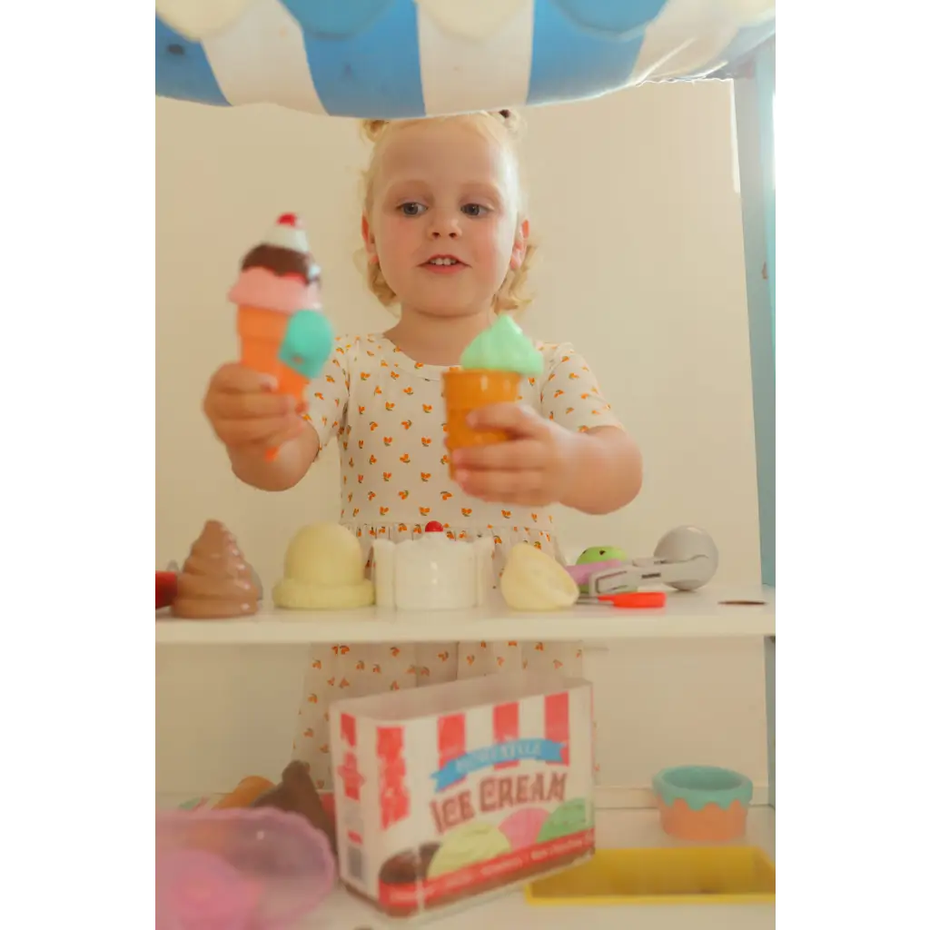 Child enjoying toy ice cream shop fun in a Lemon Shake Up Twirl Dress with floral print