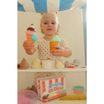 Child enjoying toy ice cream shop fun in a Lemon Shake Up Twirl Dress with floral print