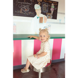 Child on retro stool in Lemon Shake Up Twirl Dress with cute floral print