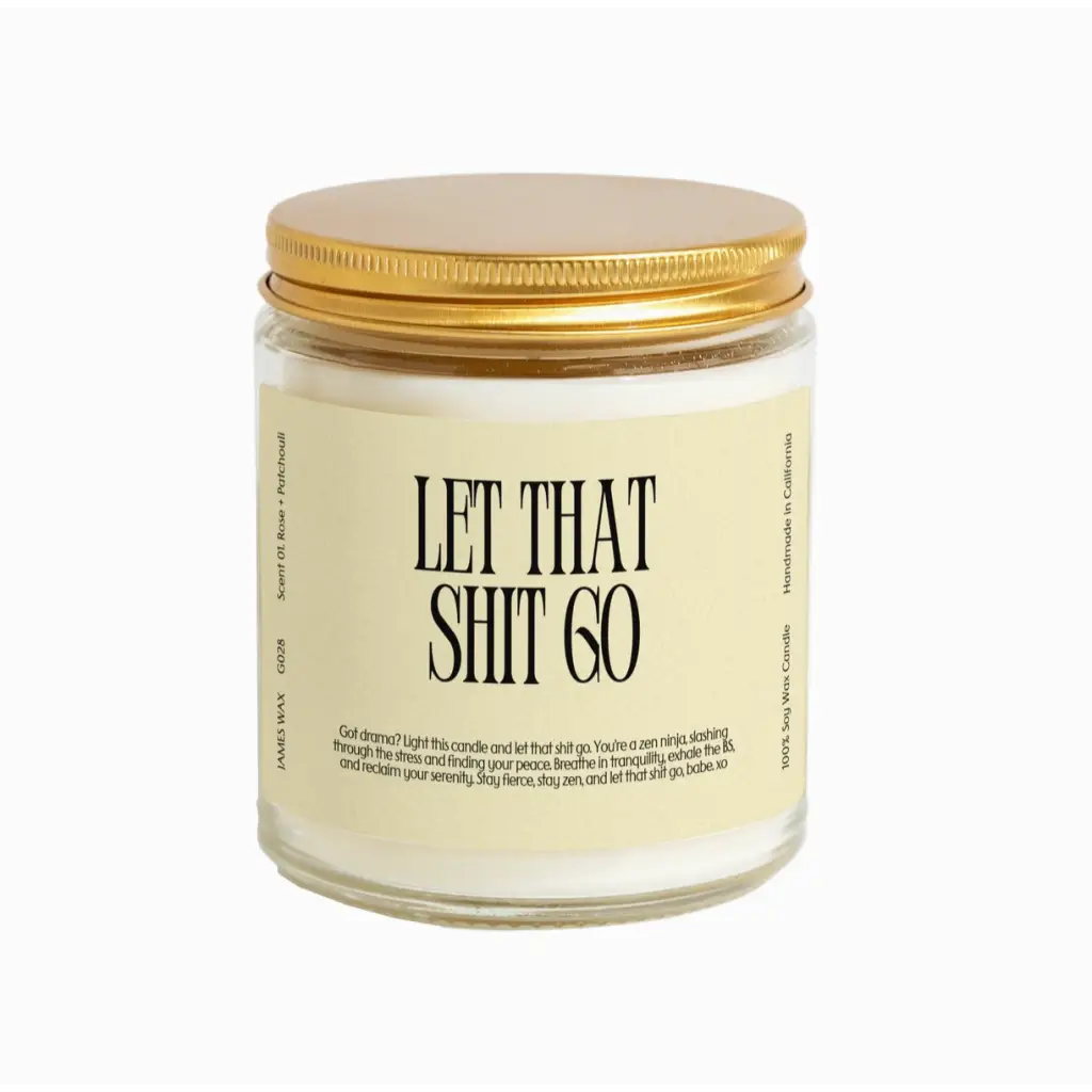 White candle in glass jar with gold lid and Let That Shit Go label, Rose + Patchouli scent