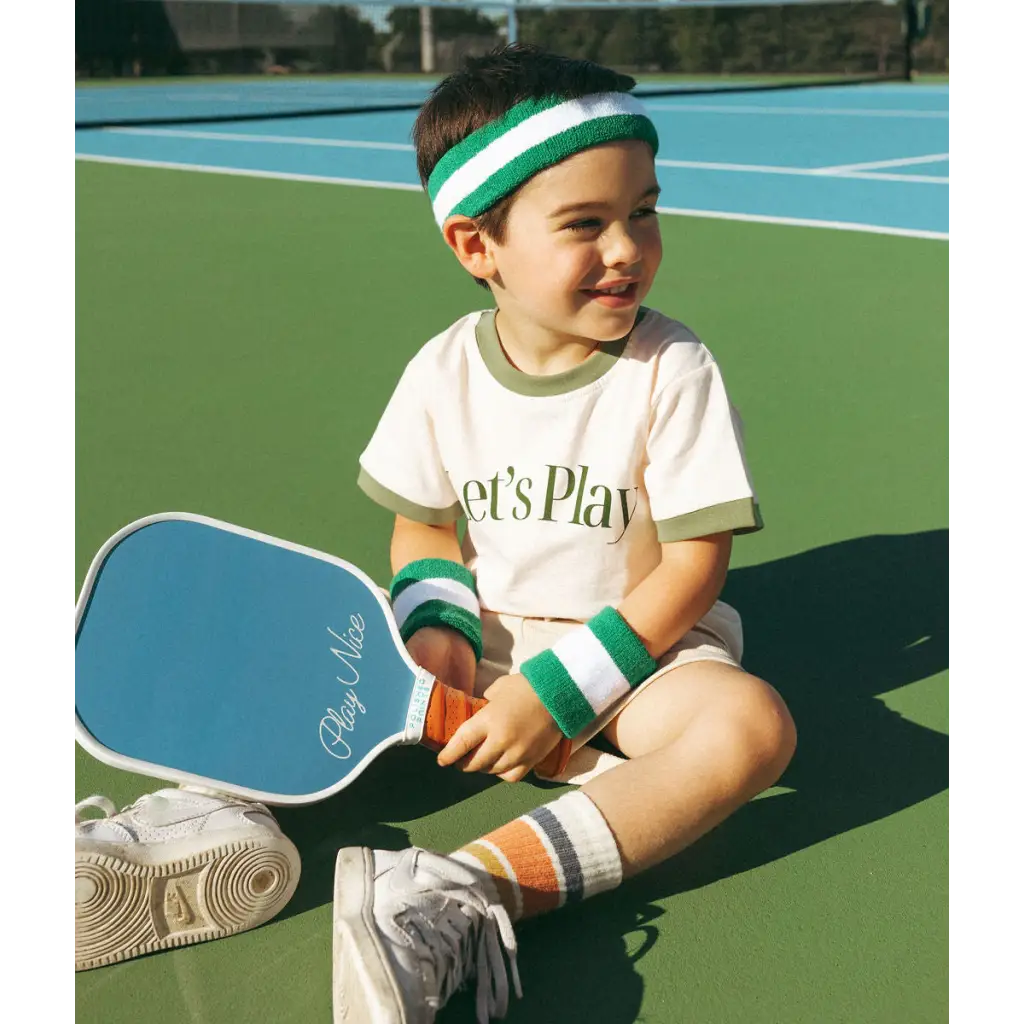 Young tennis player in a Let’s Play ringer t-shirt ready for summer fun on the court