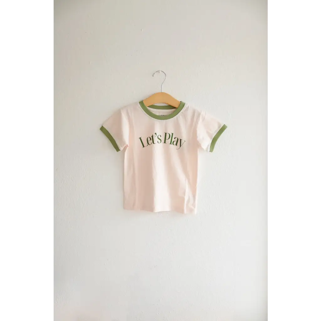 Kids Play Retro Ringer T-shirt with green trim and Let’s Play text on a hanger