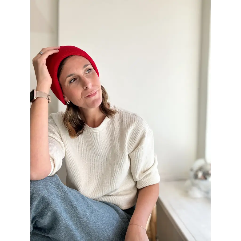 Person rocking a Lexi Beanie Hat in red with a cozy cream sweater for winter style