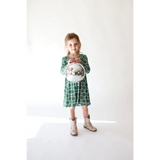 Child in a Lily Flower Check Long Sleeved Twirl Dress and beige boots, looking cute