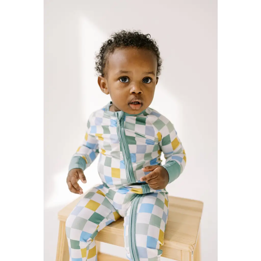 Toddler in pastel checkered zippered jumpsuit from Little Houses Bamboo Baby Sleeper