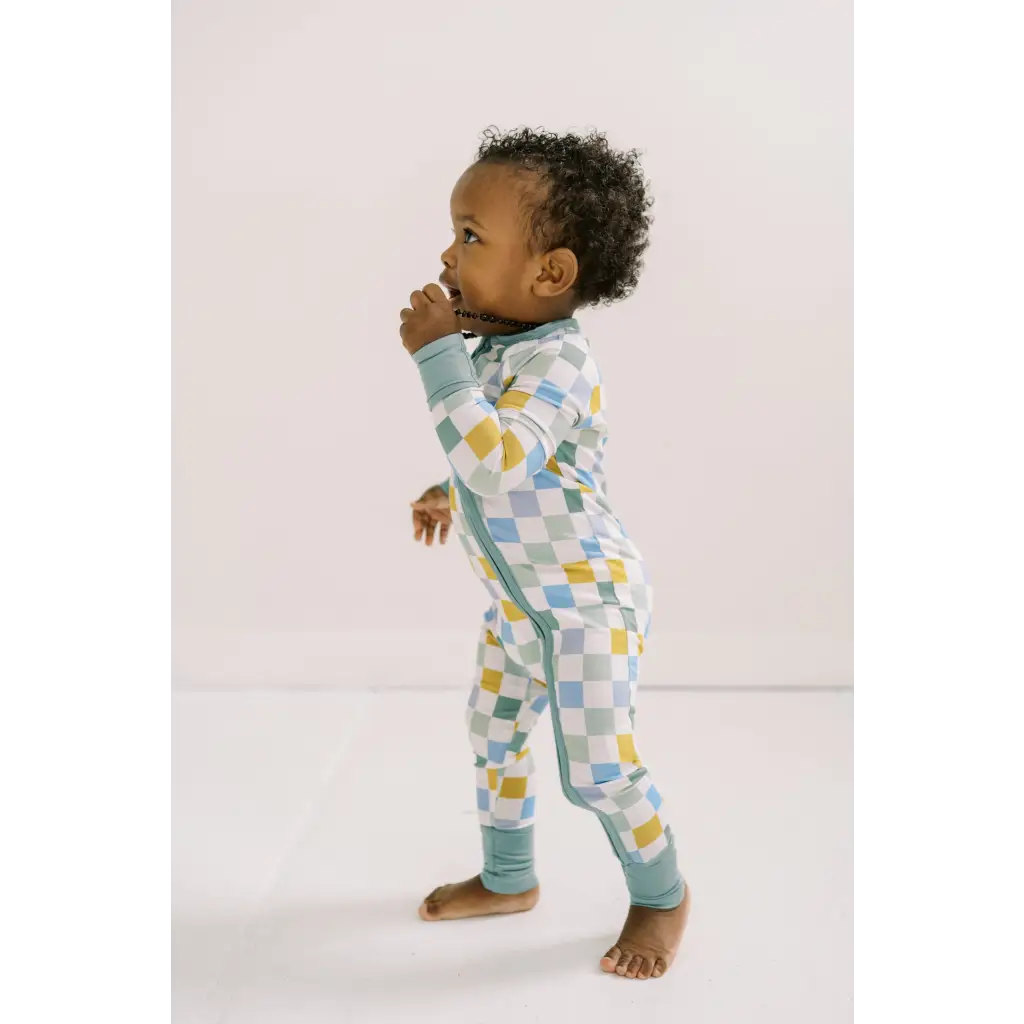 Adorable toddler in pastel checkered pajamas from Little Houses Bamboo Baby Sleeper