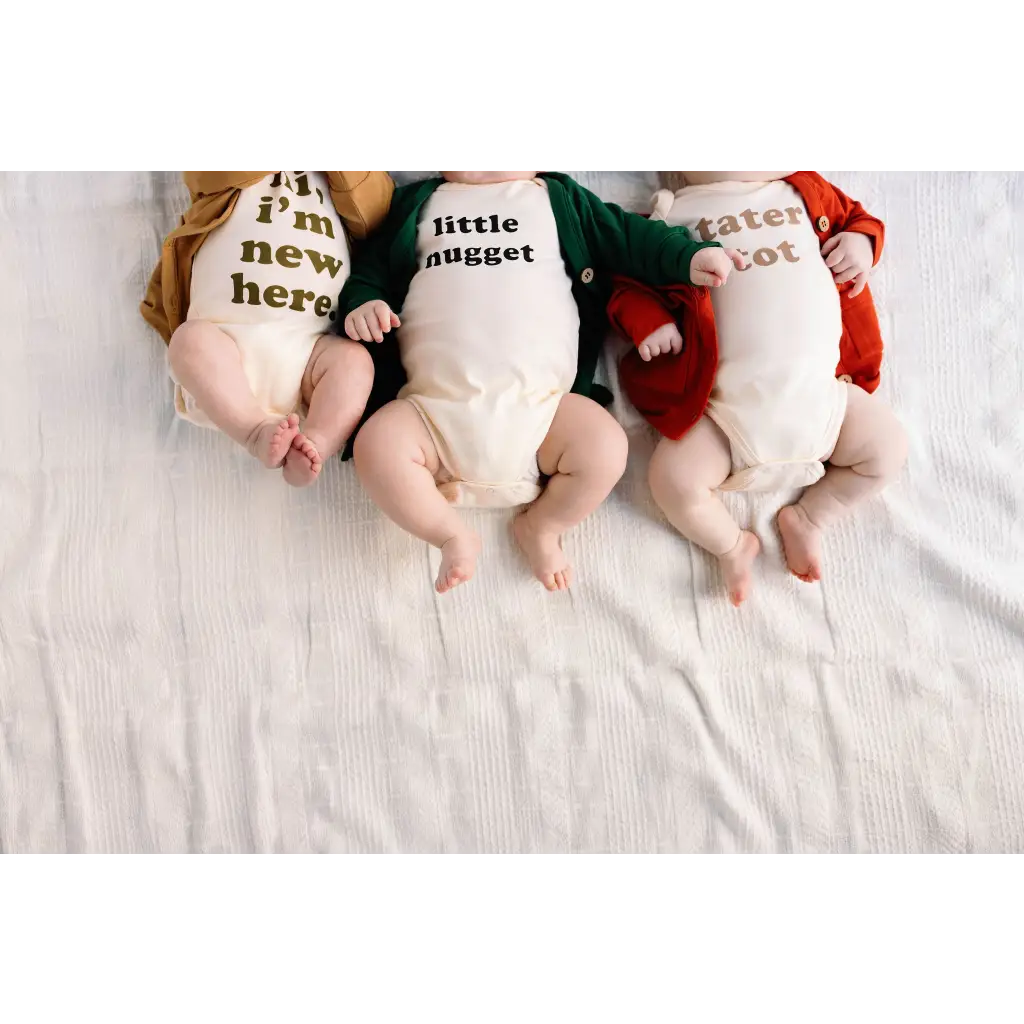 Three babies in Nugget Organic Cotton Onesies with cute text, perfect for 3mo fits closer