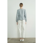 Back view of light blue peplum blouse with long sleeve denim bow and white pants outfit